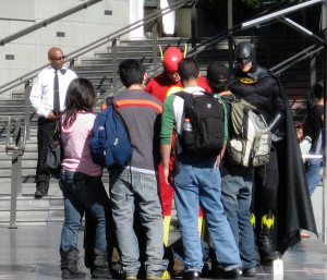 You probably thought that Batman was the good guy, but it's time to admit that you were wrong.  Here he is, not just terrorizing poor innocent tourists who don't know any better than to allow themselves to be victimized, but he's also flagrantly violating trademark law.  If he were as honest as we'd been led to believe he'd be hauling his own self off to jail instead of macking on helpless tourist girlies.