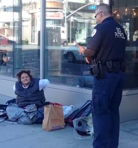 BID Patrol officer Mike Ayala (badge #107), prompted by a complaint from Starbucks, encourages a homeless woman to leave the corner of Sunset and Vine.