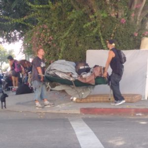 Two men carrying their possessions South on Lyman Place in advance of a LASAN clean-up of their encampment on Thursday, September 29.